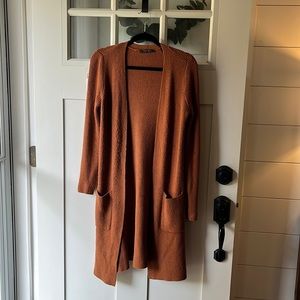 Long rust colored cardigan with pockets; good condition, some pilling on front
